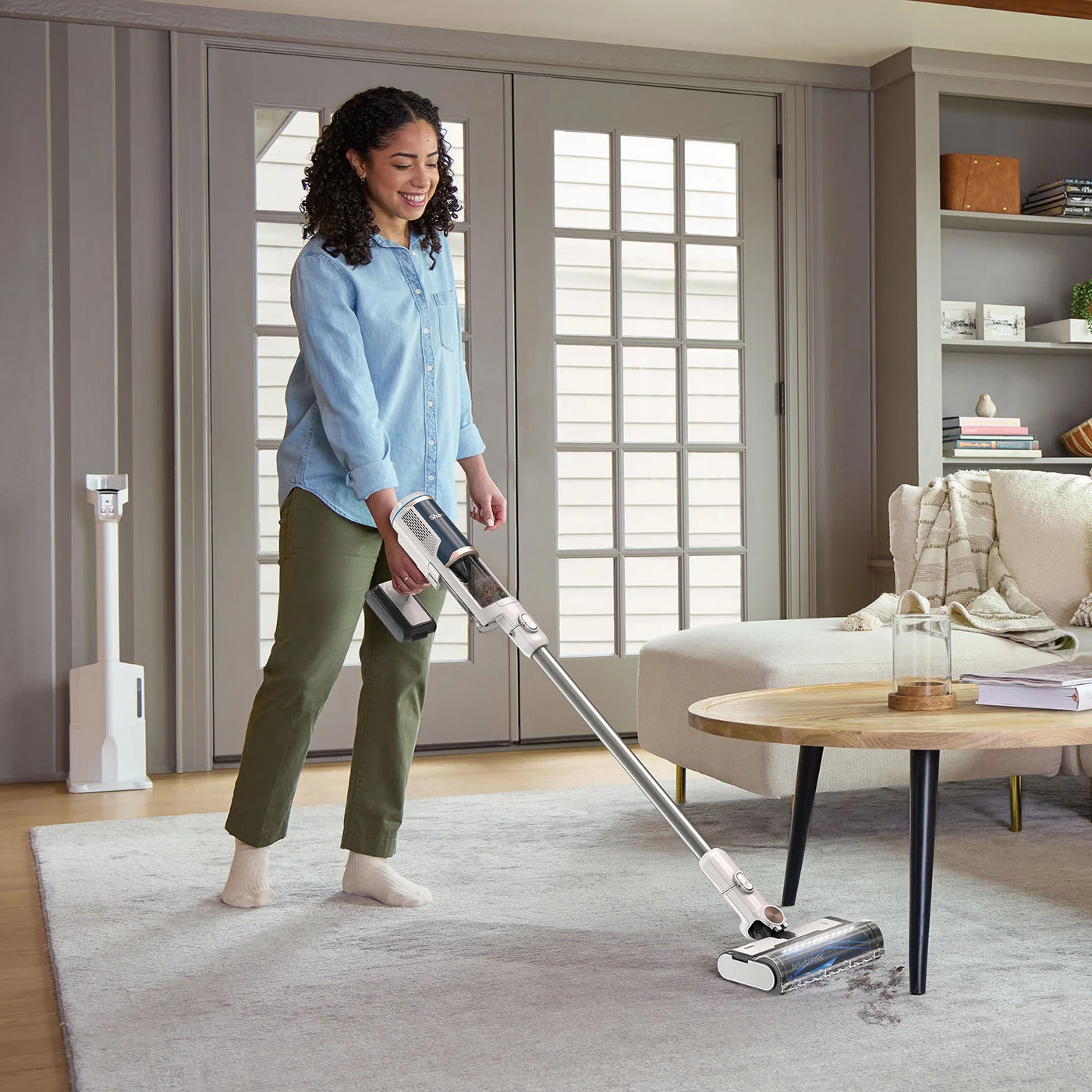 Shark-BU3521UK-InUse-LivingRoom-Rug-DustClean-Woman
